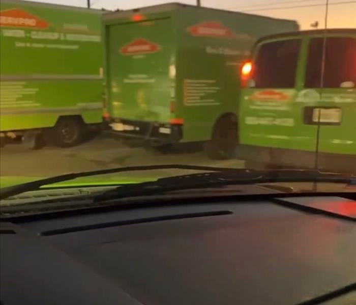 three SERVPRO green vans and box trucks